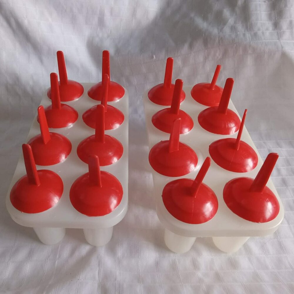 Two vintage plastic popsicle molds, perfect for making your own frozen treats.